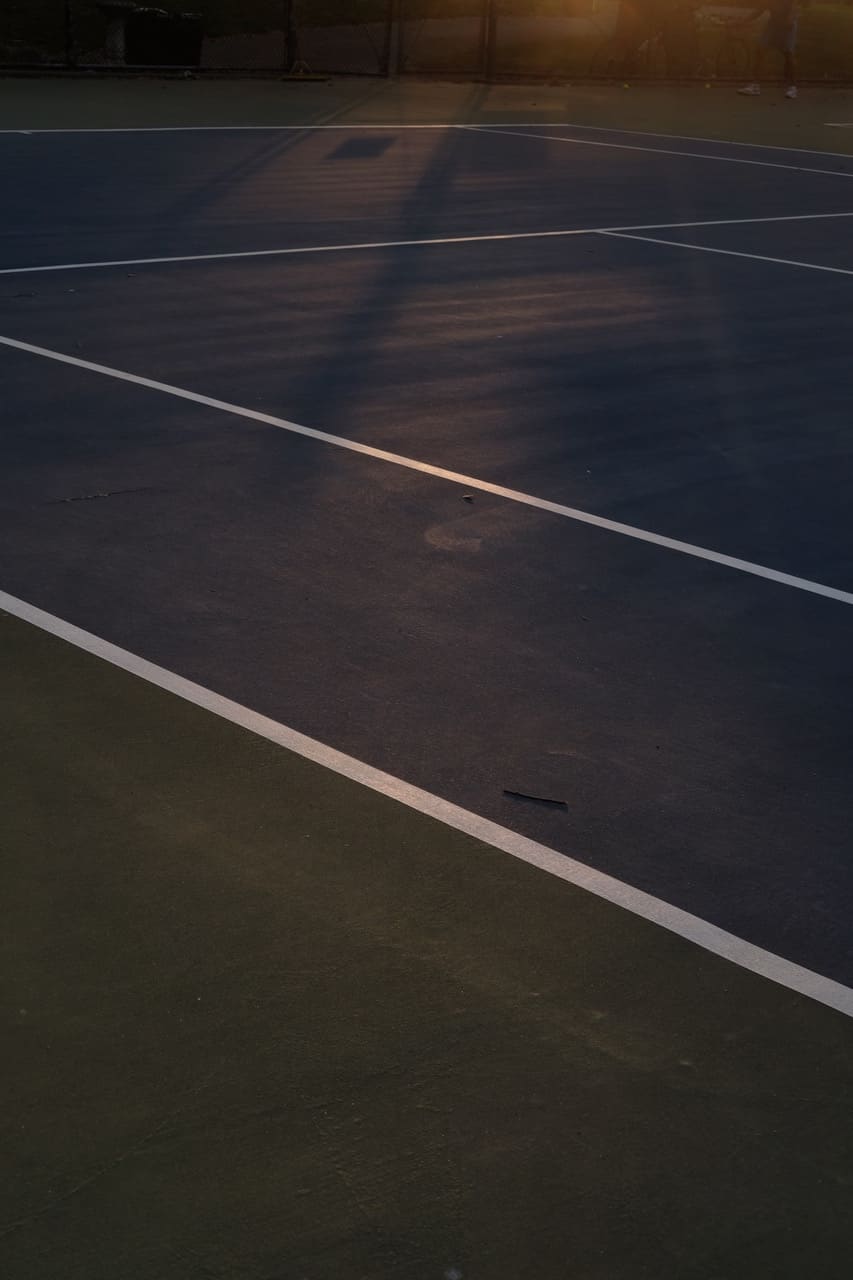 Empty New York City tennis court in late-day light